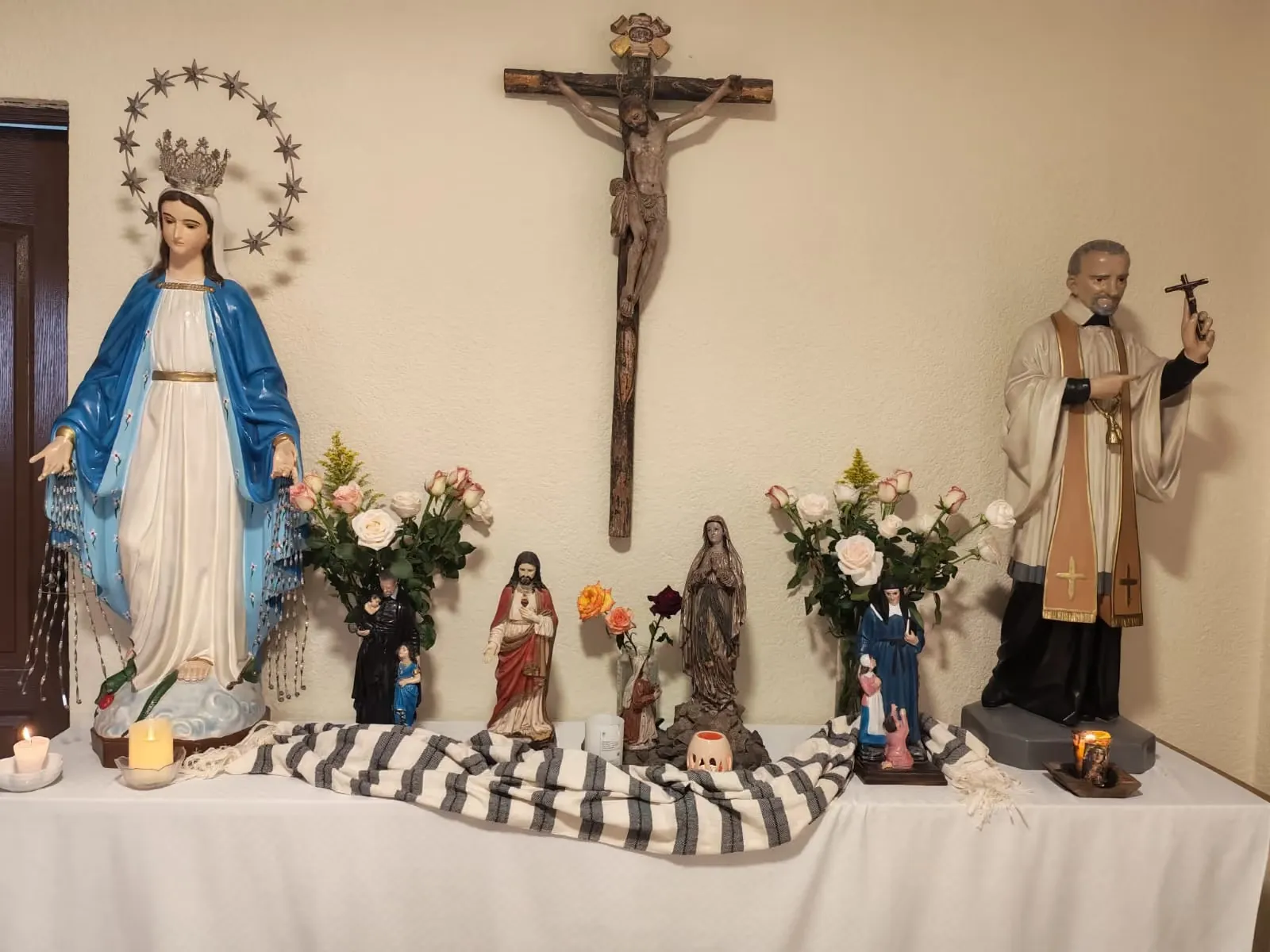 Altar con la Virgen Milagrosa, un crucifijo y flores