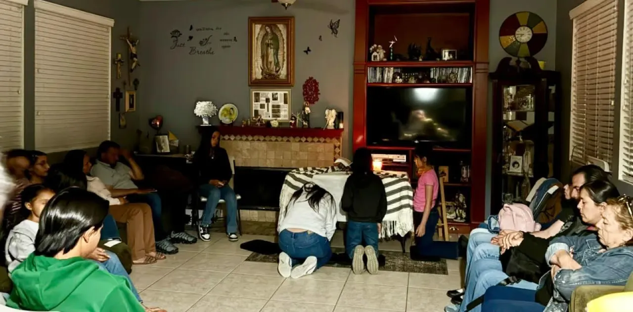Un grupo reunido en oración en una sala